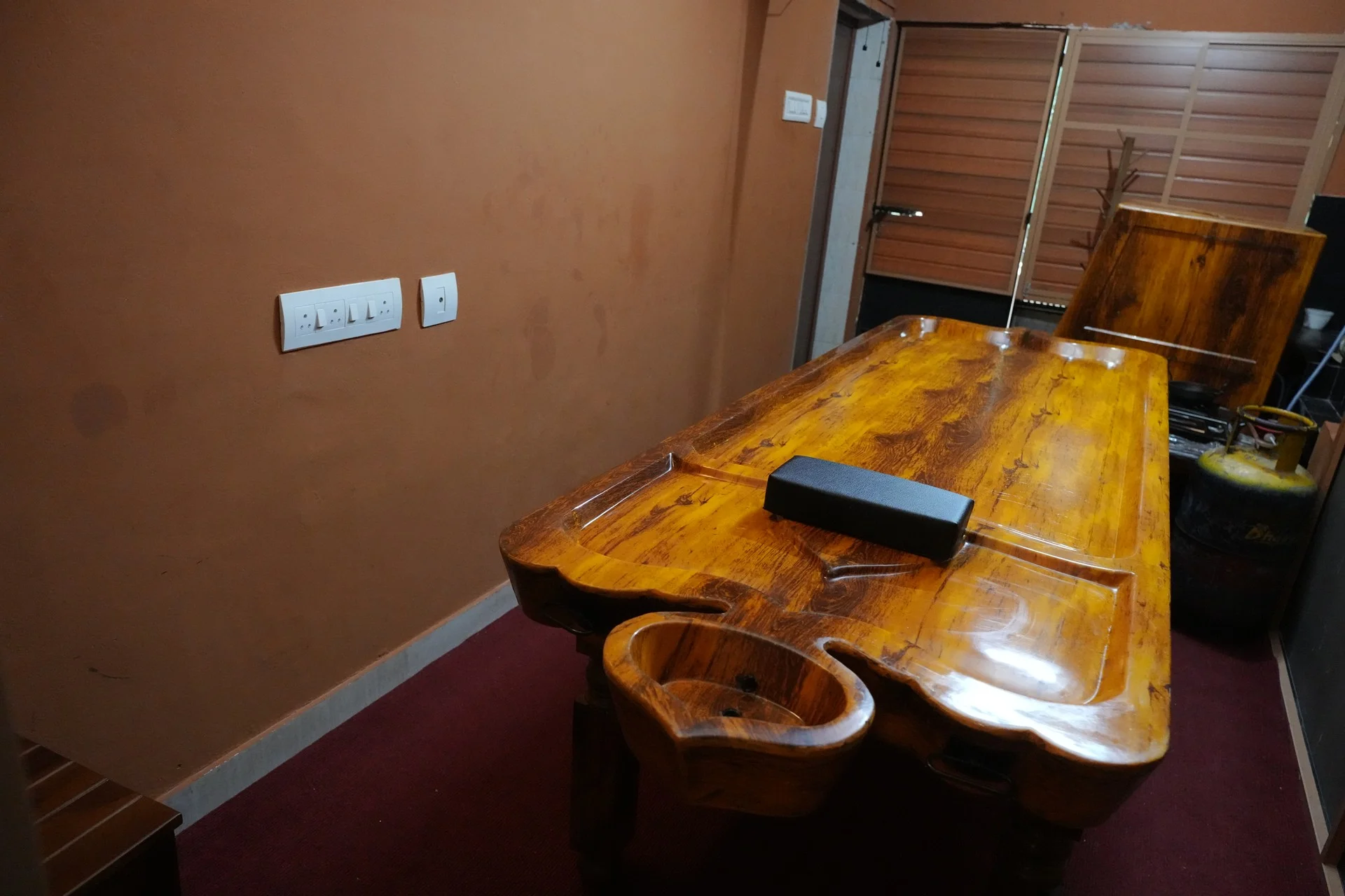 Authentic wooden droni treatment table and herbal steam chamber at Sanyu Ayurveda