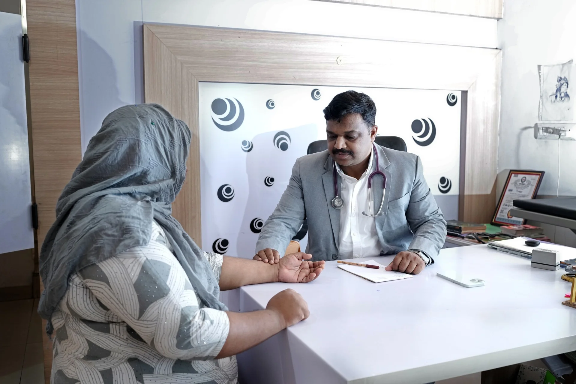 An Ayurvedic physician listening to a patient while reading her pulse